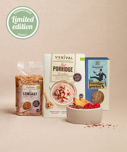 Das Set "Morning Bliss" (klein) von Verival mit Bio Bircher Porridge, Samenmischung und Porridge Gewürz wird mit einer Porridge-Schale mit Früchten präsentiert. Eine kleine Plakette in limitierter Auflage ist ebenfalls zu sehen.